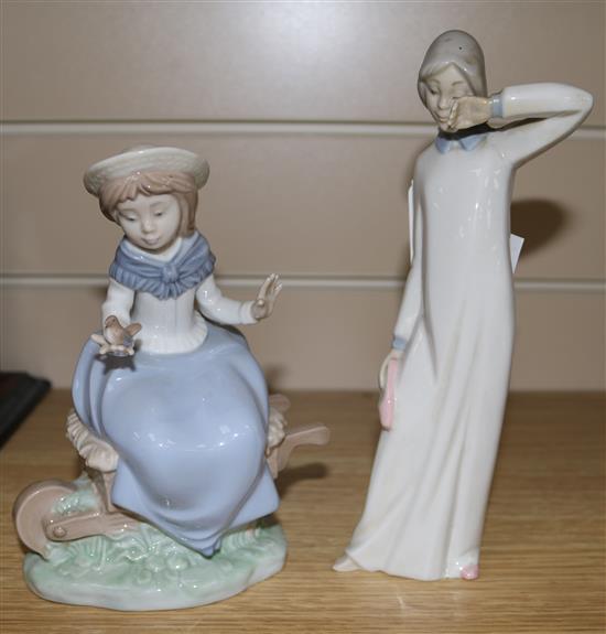 A Nao figure of a girl sitting on a wheelbarrow and one other (2)
